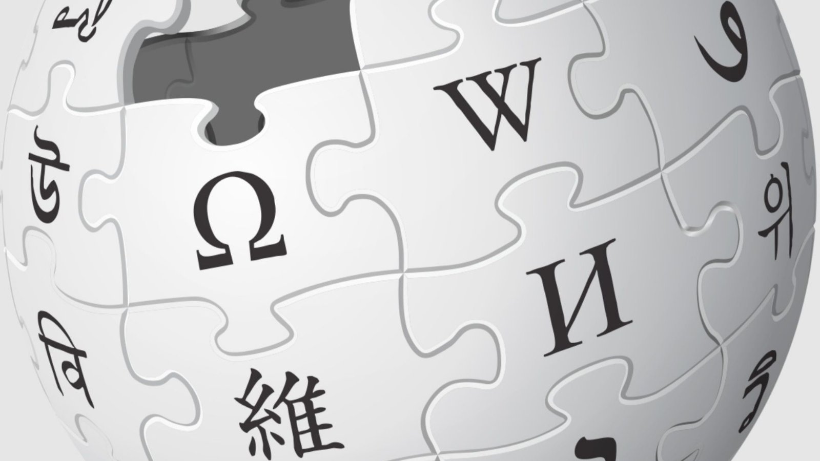 Um globo de quebra-cabeça branco e cinza, logotipo da Wikipédia, exibe caracteres de múltiplos idiomas com uma peça faltando no topo.